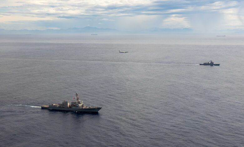 U.S. Navy and Philippine Navy ships conduct maritime exercise with aircraft overhead.