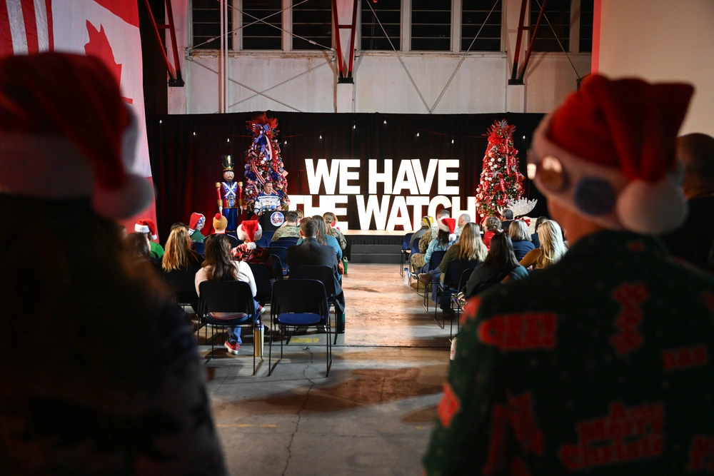 NORAD Tracks Santa event with "WE HAVE THE WATCH" banner and Christmas trees.
