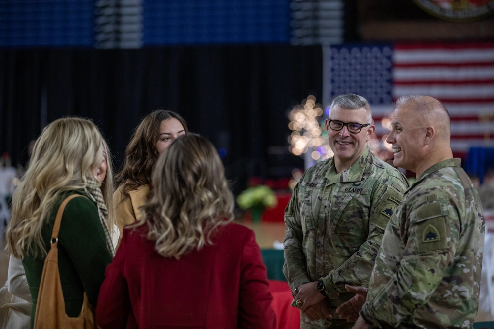 Army Guard members share a holiday meal, celebrating together in uniform with families and friends.