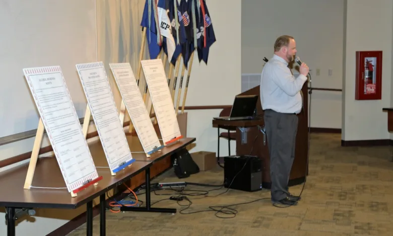 Speaker at podium with substance misuse awareness posters.