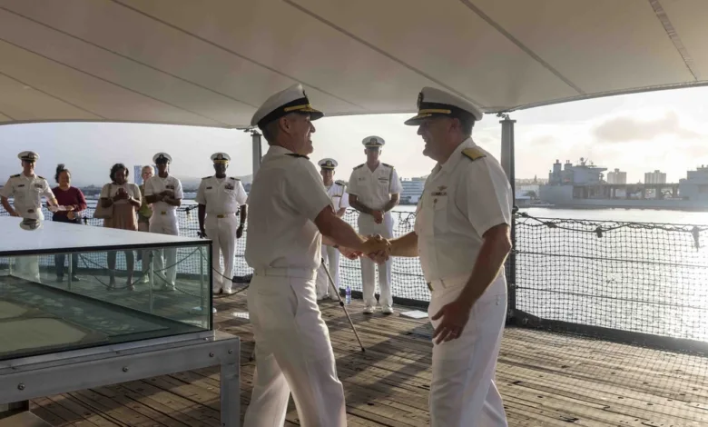 Navy officers shake hands during a promotion ceremony in Hawaii.