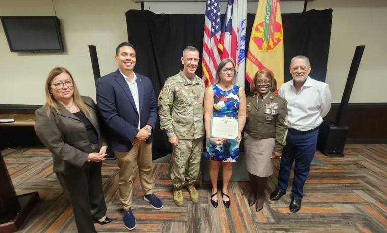Fort Buchanan honors civilian retirees with group photo near flags.