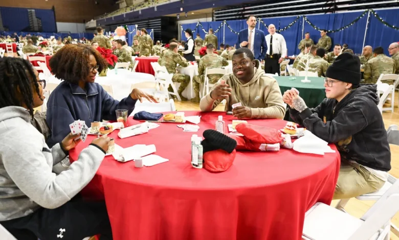 Guard members at D.C. Armory share a holiday celebration, playing cards at a table with a red tablecloth.