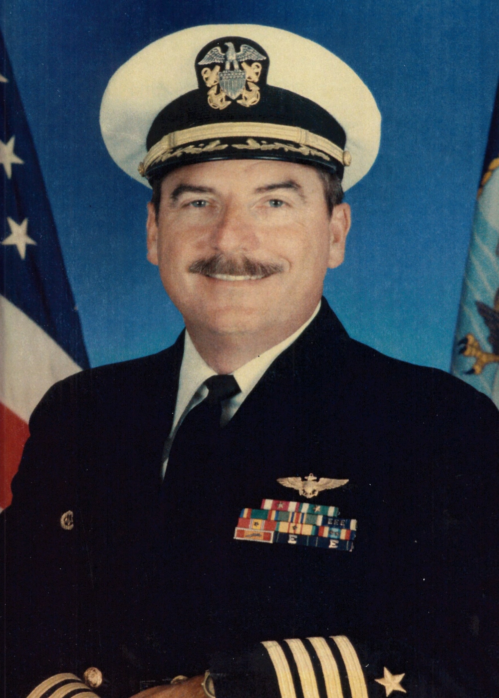 Capt. Roger Hill in US Navy uniform with ribbons and insignia, honoring his service at NAS Patuxent River.