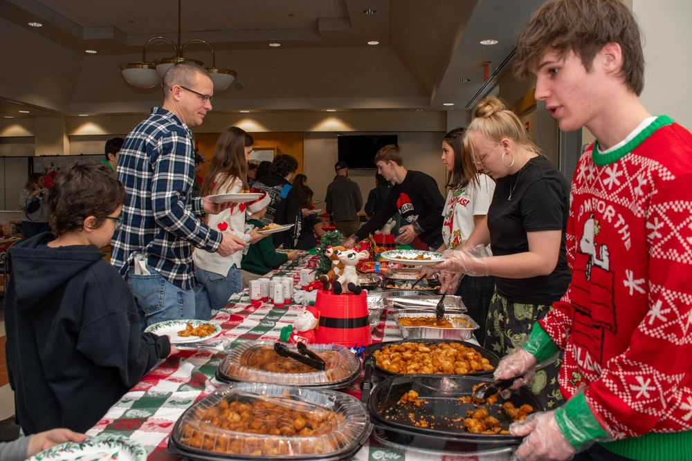People at a holiday buffet, possibly the 2025 Oncology/Hematology Christmas Party.
