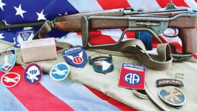 M1A1 Carbine with Airborne patches and American flag. "Airborne" and "Carbine, Caliber .30MI" text visible.
