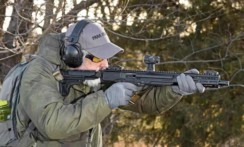 Man shooting Ruger LC Carbine in .45 ACP, wearing ear protection and grey gloves.