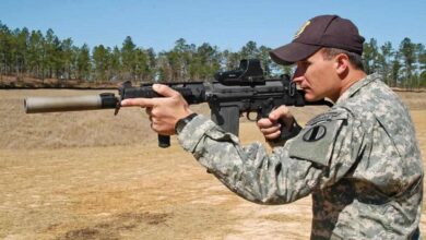 Soldier firing an 11-inch FAL shorty rifle with suppressor at the AMU range.
