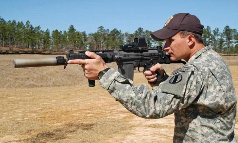 Soldier firing an 11-inch FAL shorty rifle with suppressor at the AMU range.