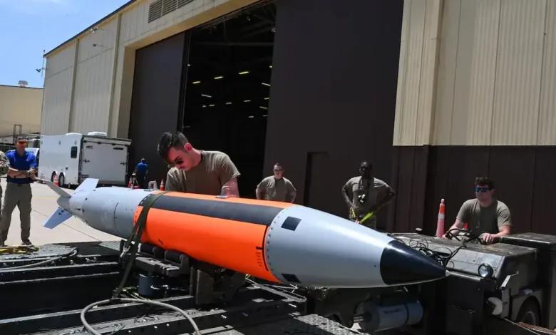 Airmen preparing a B61 nuclear bomb, showcasing US military equipment.