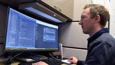 Air Force personnel working on NIPRGPT generative AI platform code on a computer.