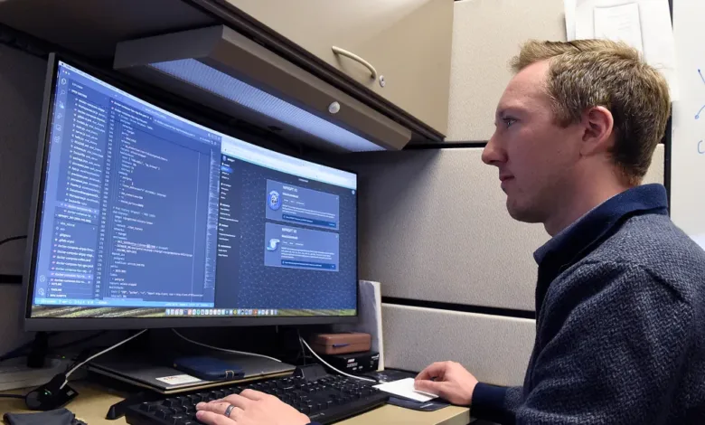 Air Force personnel working on NIPRGPT generative AI platform code on a computer.