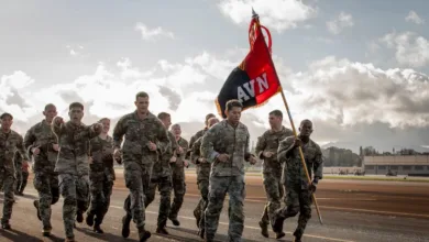 Army soldiers running with AVN flag, military training exercise.