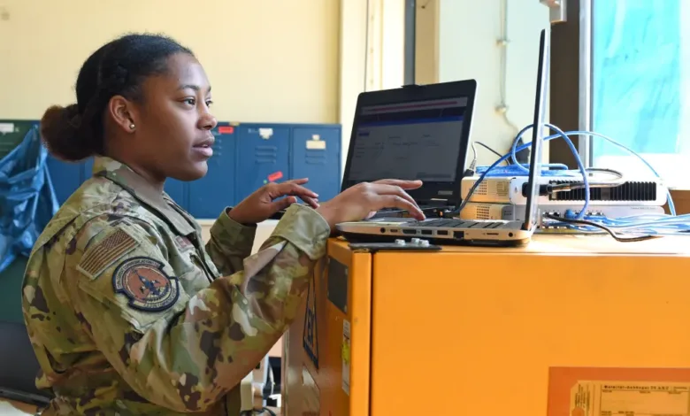 Air National Guard member works on a laptop, likely in cyber operations at a Louisiana base.