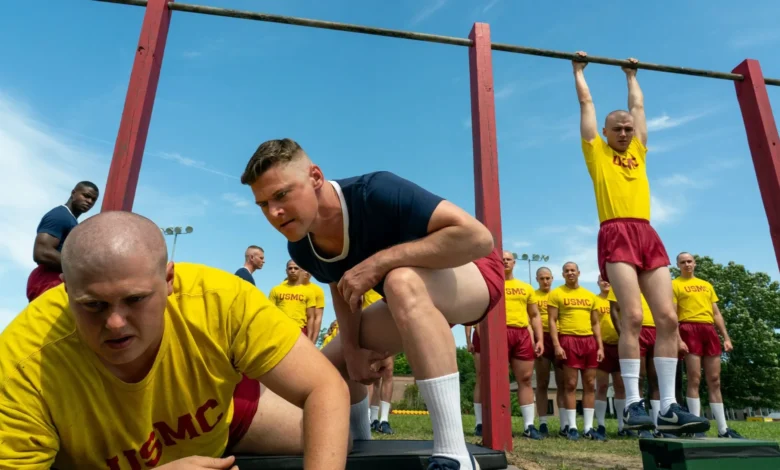 US Marine recruits training outdoors, doing pull-ups and squats.