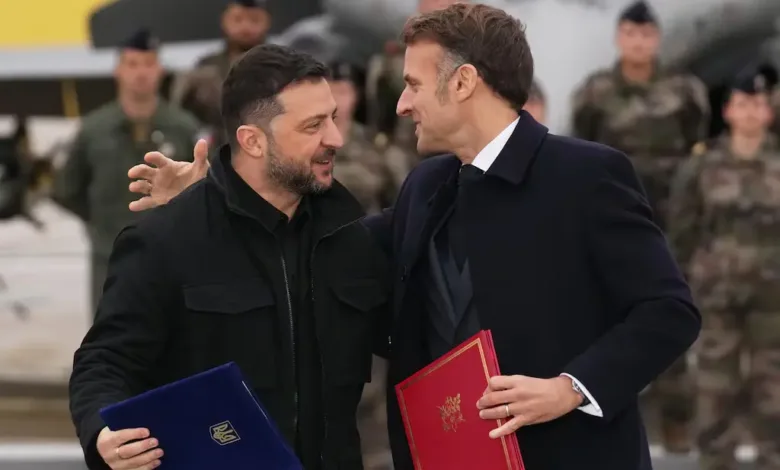 Zelenskyy and Macron meet, holding documents. Ukraine and France strengthen ties.
