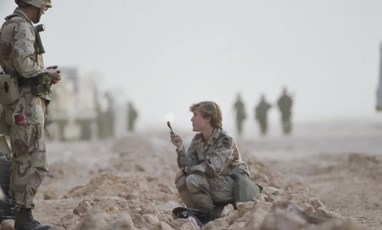 Soldier in desert camouflage holds a spoon, Gulf War setting.