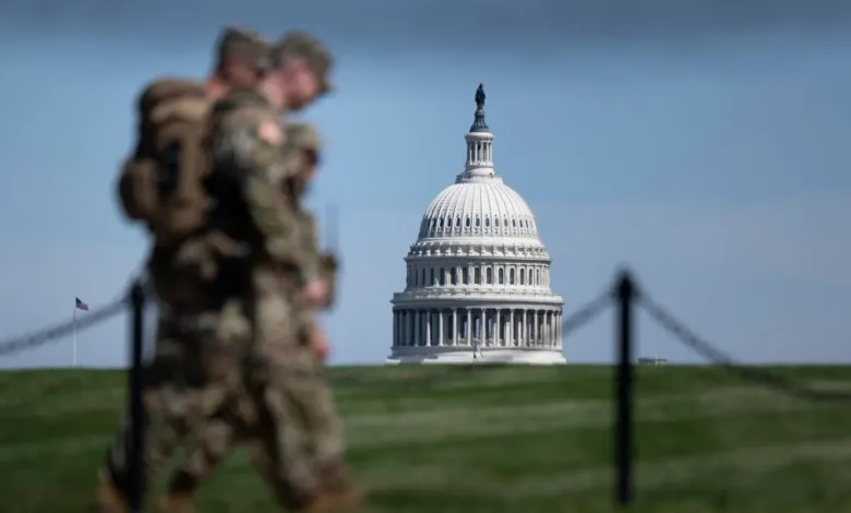 U.S. Capitol Building with National Guard troops walking by.