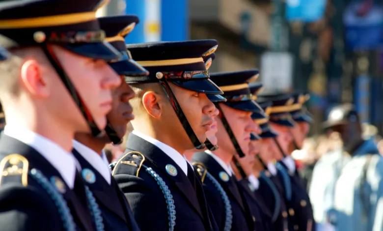 Military honor guard in dress uniform, standing in formation.