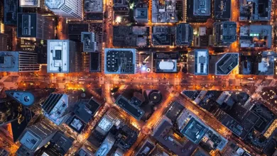 Aerial view of a city at night, showcasing illuminated buildings and streets.