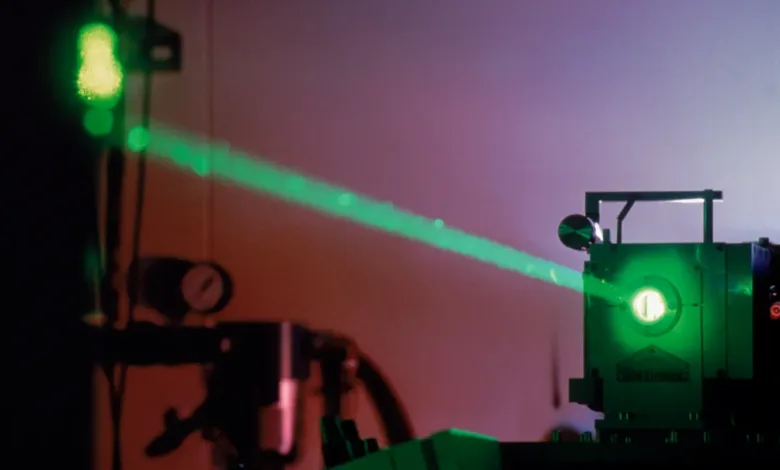 Green laser beam emanating from a laser weapon system, potentially for drone defense.