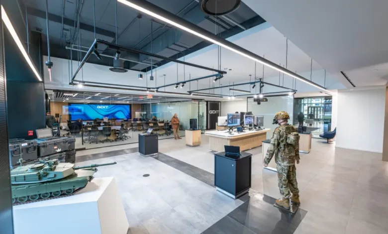 GDIT tech hub interior with soldier, tank model, and collaboration space.