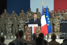 French President Macron addresses troops with French flag, possibly related to PA-Ng aircraft carrier production.