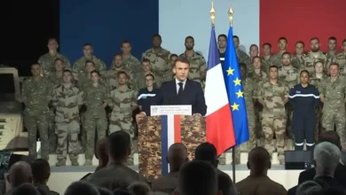 French President Macron addresses troops with French flag, possibly related to PA-Ng aircraft carrier production.