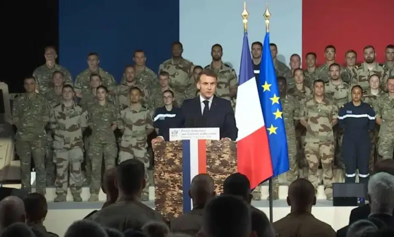 French President Macron addresses troops with French flag, possibly related to PA-Ng aircraft carrier production.