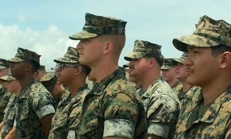US Marines in camouflage uniforms stand at attention.