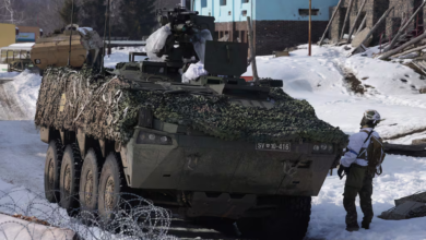 Slovenian Patria armored vehicle with camouflage netting in a snowy environment. SV 10-416 license plate visible.