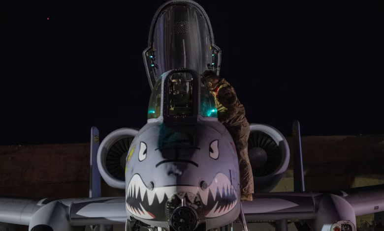 A-10 Thunderbolt II with shark teeth nose art being inspected at night.