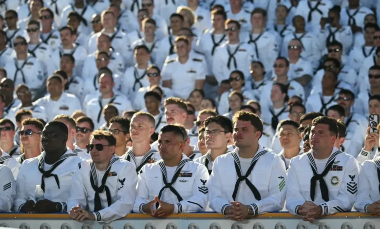 US Navy sailors in dress whites at an event. Pentagon paying troops.