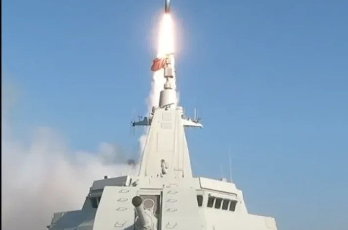 Chinese Navy destroyer launching missile at sea, bright sky background