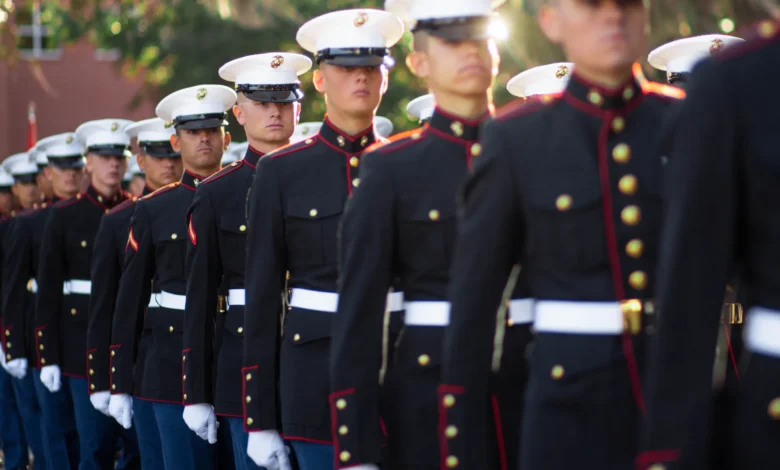 Marines in dress blues stand in formation.