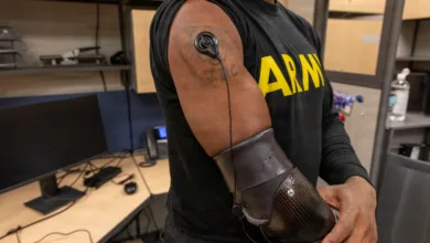 Soldier with prosthetic arm and sensor on bicep wearing an ARMY shirt.