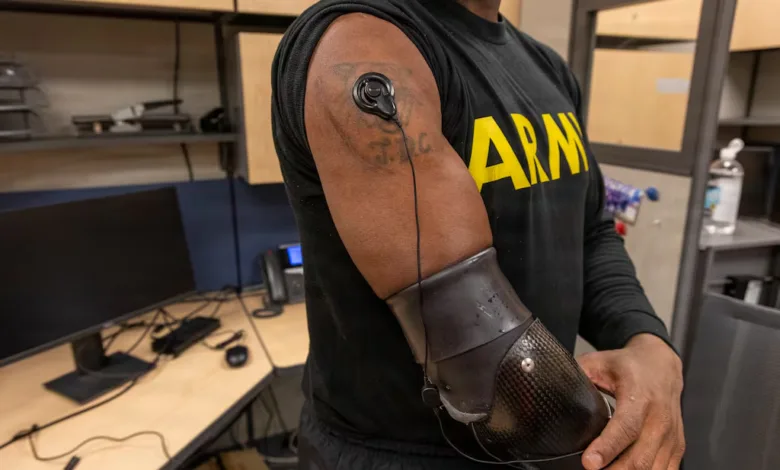 Soldier with prosthetic arm and sensor on bicep wearing an ARMY shirt.