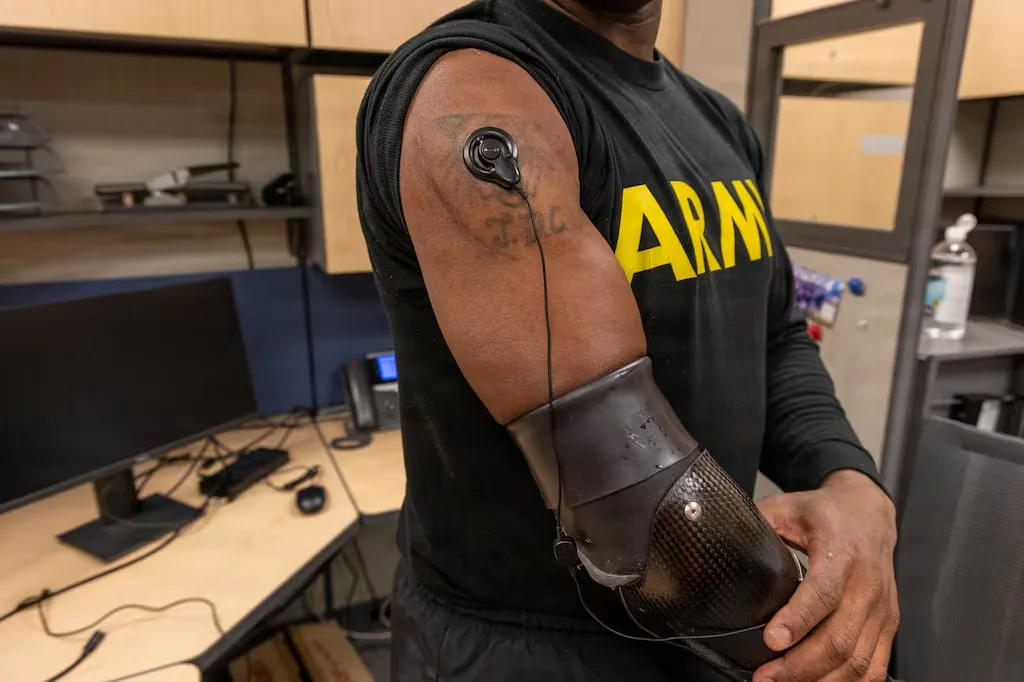 Soldier with prosthetic arm and sensor on bicep wearing an ARMY shirt.