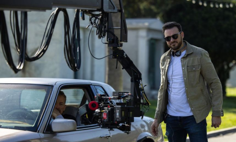 Film crew filming scene for 'Hollywood Grit' with camera crane and vintage car.