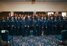 Large group of Air Force officers in dress uniforms posing indoors.