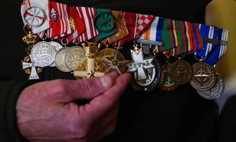 Danish veteran's medals, including Danish war medals, being held up for display.
