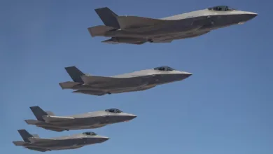 Four F-35 fighter jets flying in formation against a clear blue sky.