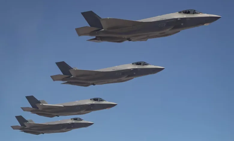 Four F-35 fighter jets flying in formation against a clear blue sky.