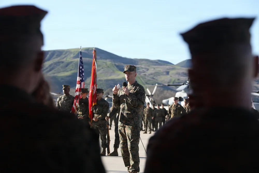 Marine officer speaking at HMLA-169 change of command ceremony. US flag visible.