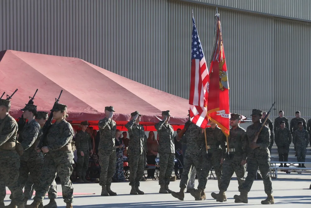 Marines in formation during HMLA-169 change of command ceremony, saluting flags.