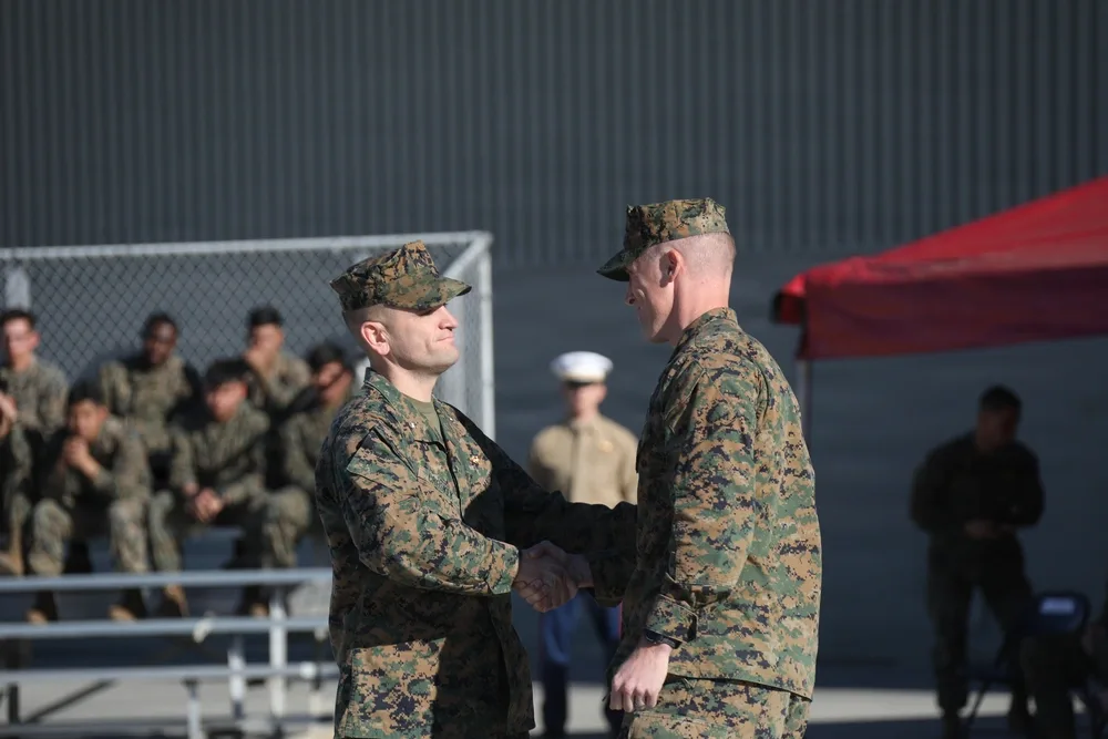 Two Marines shaking hands in uniform at HMLA-169 change of command ceremony.