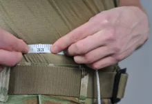 Measuring waist size with tape measure showing 33 inches.
