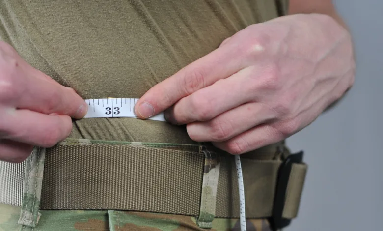 Measuring waist size with tape measure showing 33 inches.