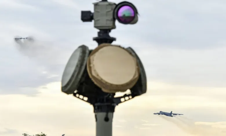 Military radar system with B-52 bombers in the background.