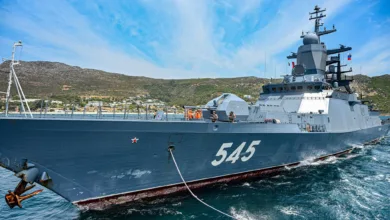 Russian Navy corvette "Stoikiy" (545) underway, docked near mountains under a blue sky.